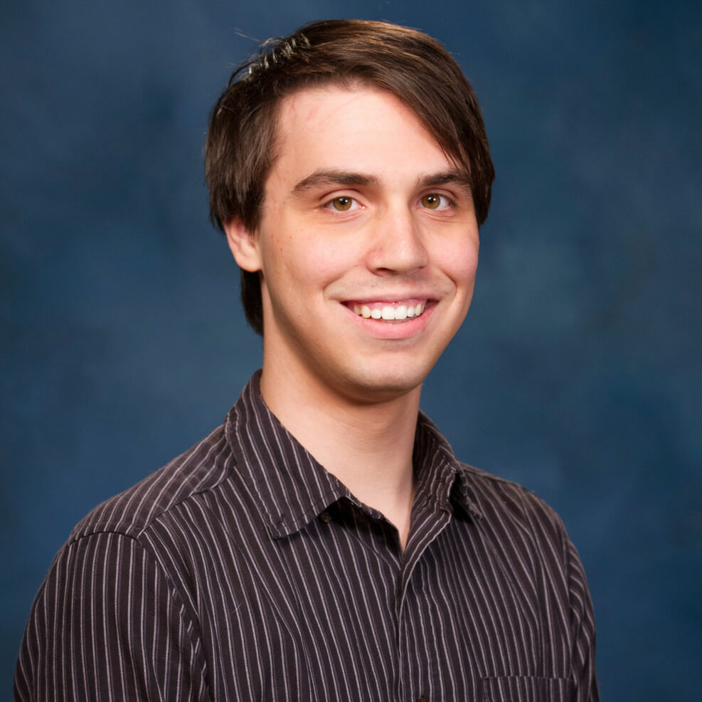 A picture of Tyler Westland in a striped collared shirt.