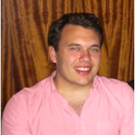 An image of John. He is wearing a pink button-up shirt. 