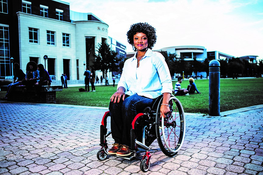 A photo of Centra Mazyck on a wheelchair smiling at the camera.