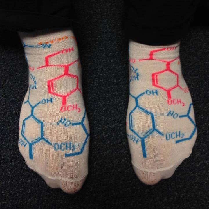 A picture of feet wearing socks that show the skeletal formula of various molecules. These formulas are either in blue or pink.